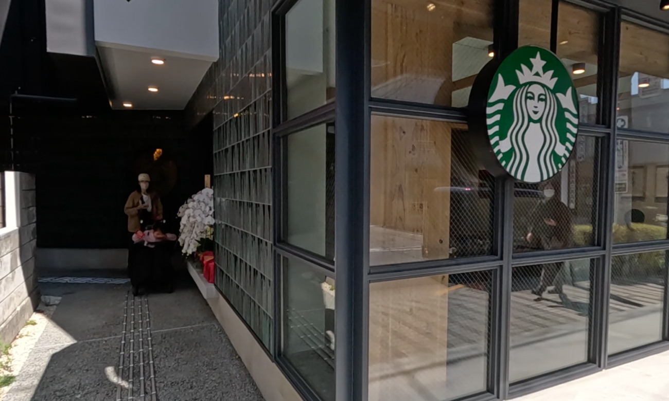スターバックスの入口は道路側につくらず、左側の路地を抜けていくと入口があるという形にした